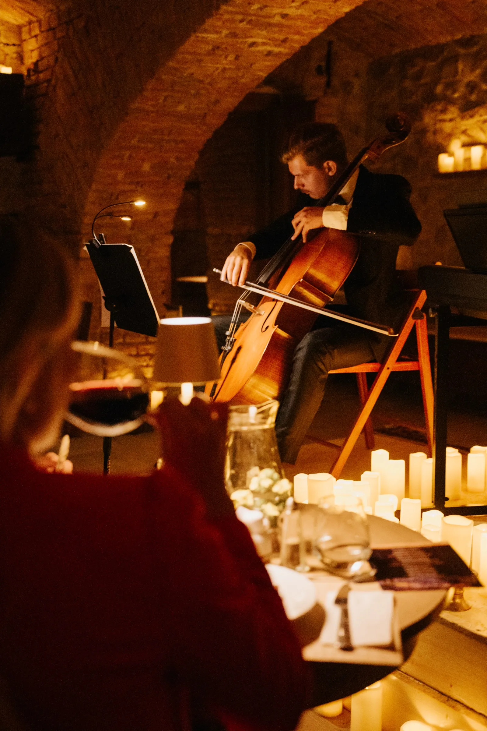 Cellist performing in a candlelit cellar