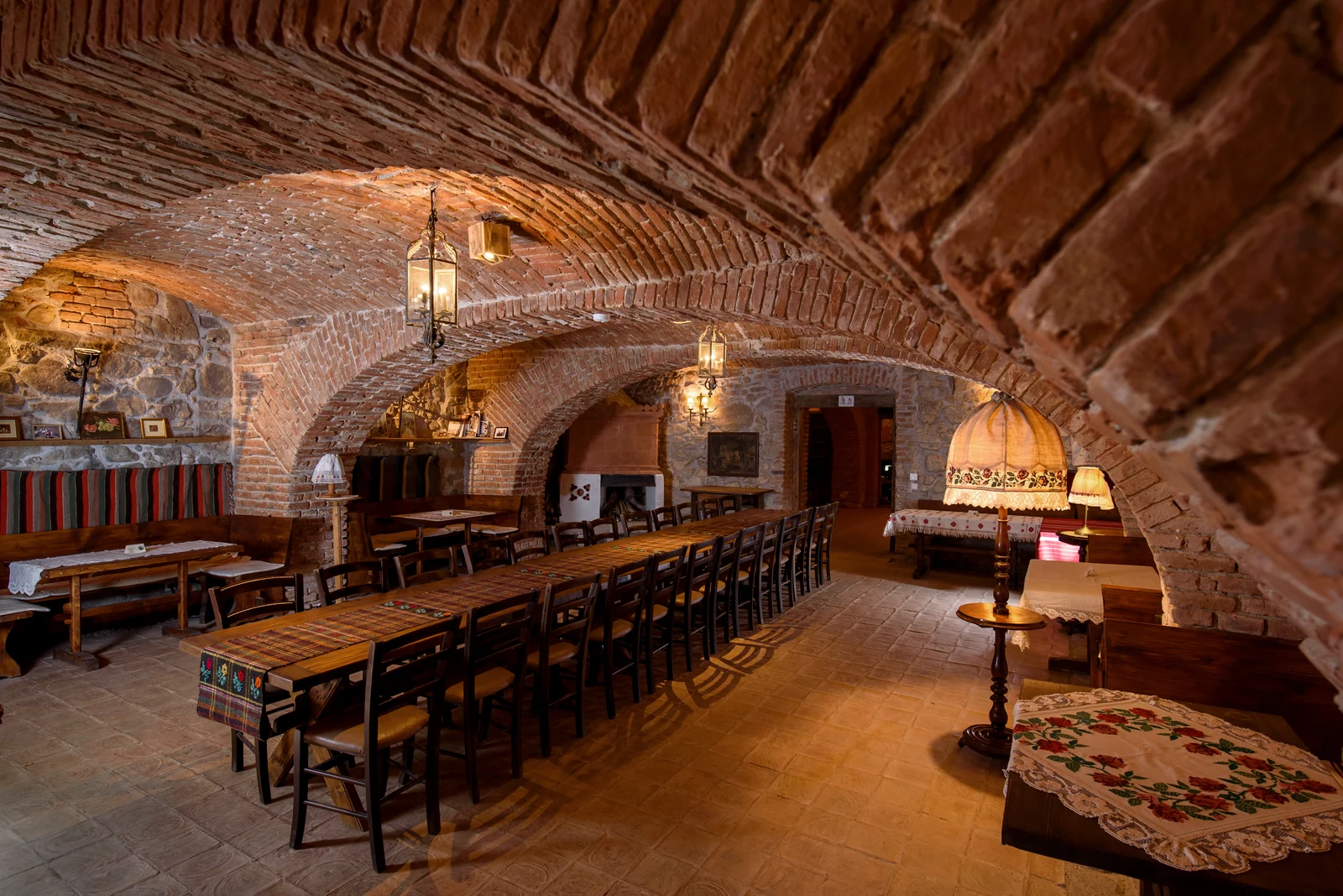 Long wooden tables beneath the brick vaults of the castle cellar
