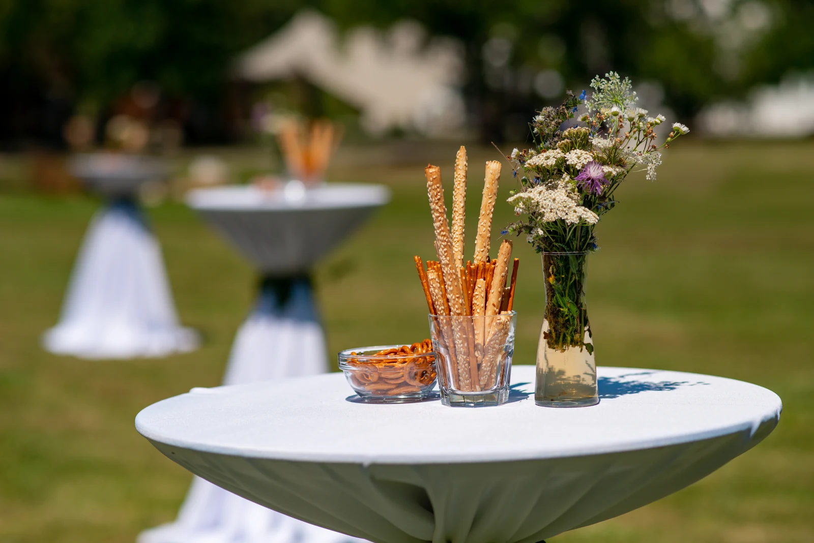 Flowers and savoury snacks on a courtyard reception table at Miklósvár Castle