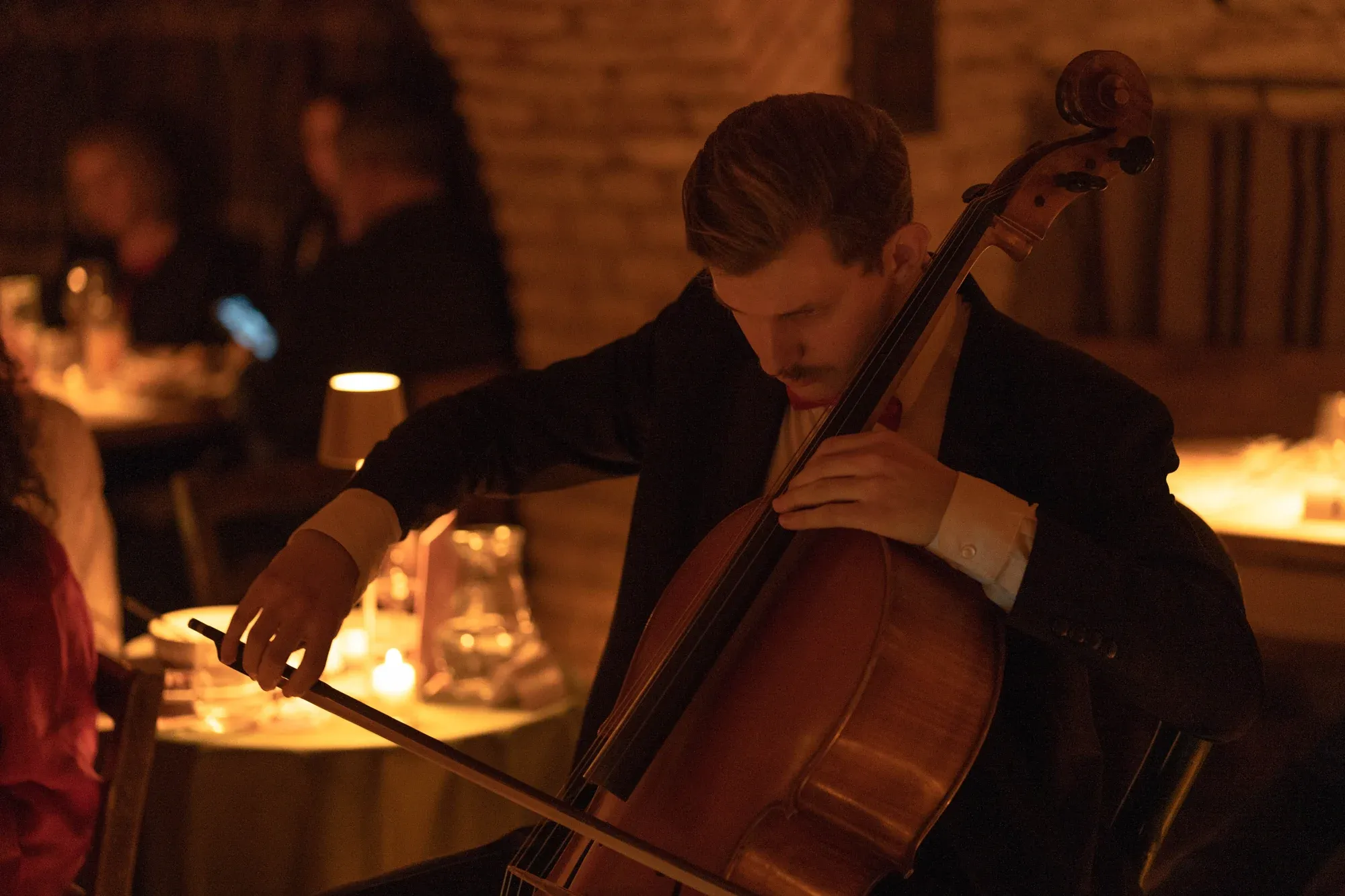 A cellist playing in the warm candlelight of the castle wine cellar