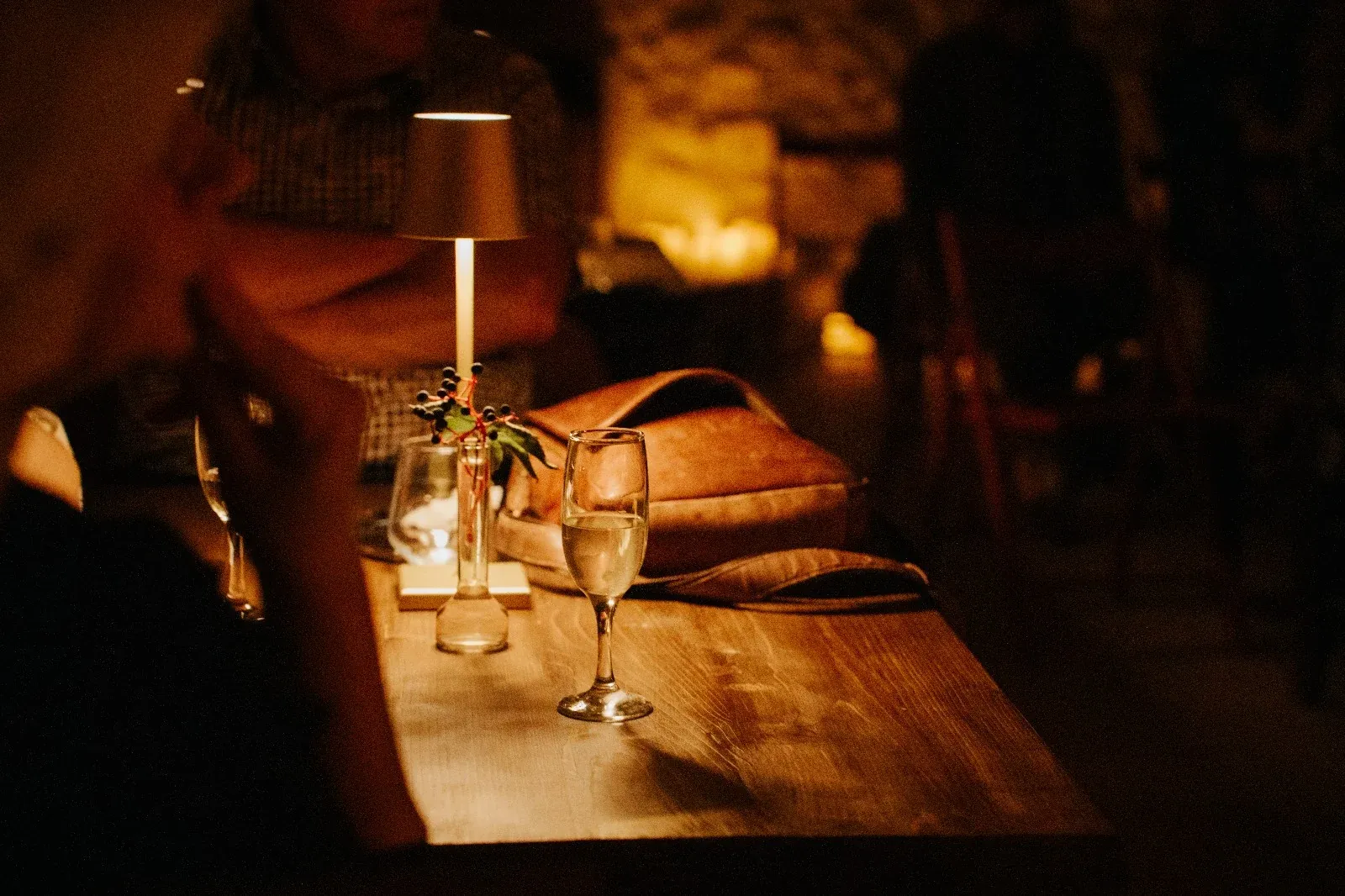 Dinner tables set with glasses and small lamps for concert guests