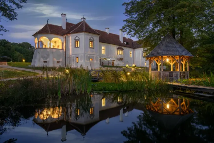 Kálnoky Castle in Micloșoara reflected in the pond at dusk