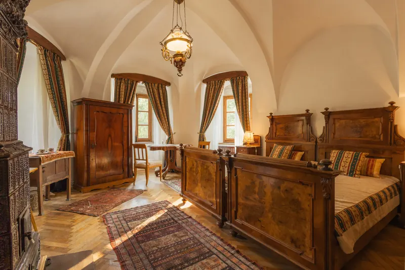 The Bishop’s Room inside Miklósvár Castle, with a vaulted ceiling and carved wooden beds