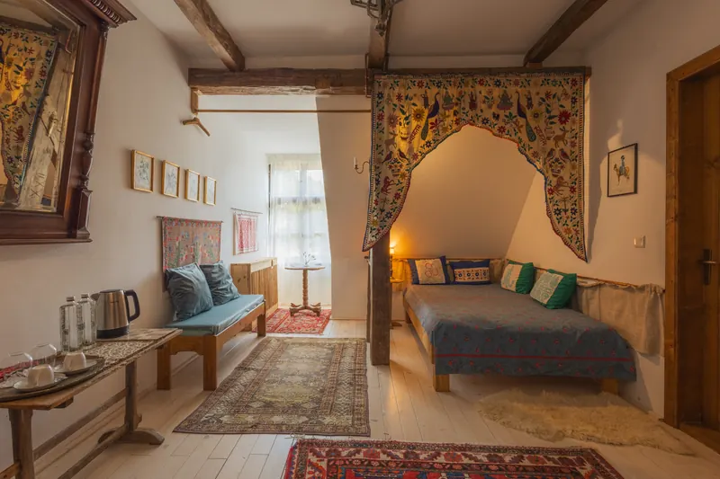 The Groom’s Room inside Miklósvár Castle, with a curtained alcove bed and painted furniture